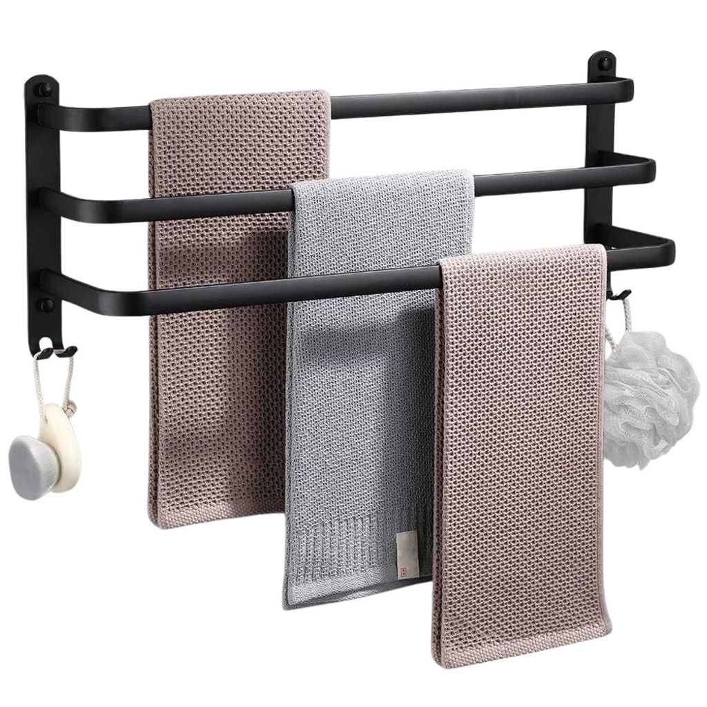 A black aluminum towel rack with three bars, holding three different towels and a bath puff.