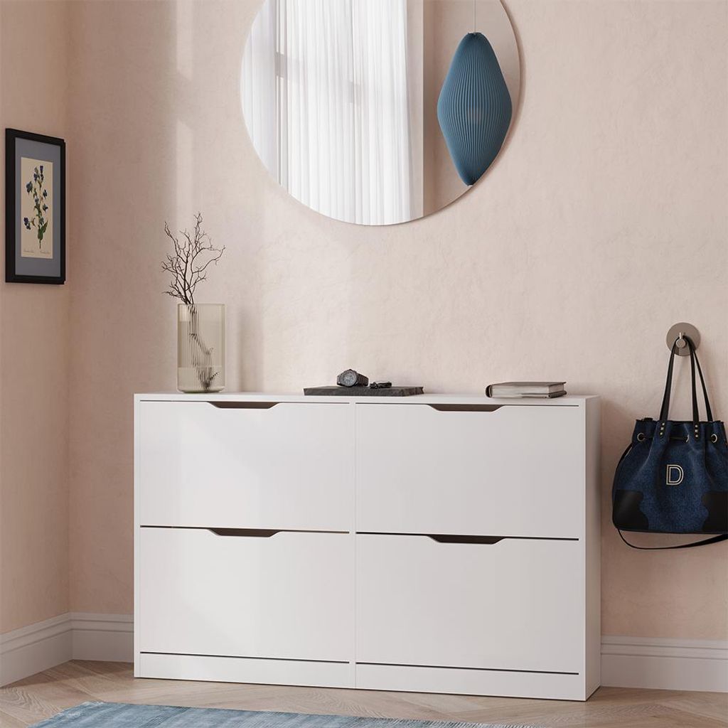 A white shoe cabinet with four drawers is shown in a room with light pink walls.