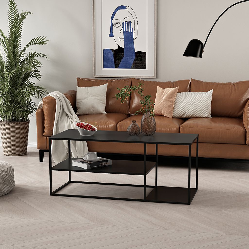 A modern living room scene featuring a brown leather couch, a black coffee table, and a large abstract painting on the wall.