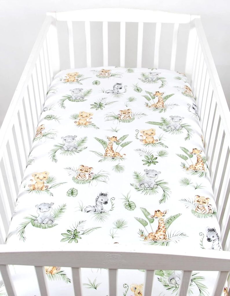 A crib with a fitted sheet featuring a jungle animal print.