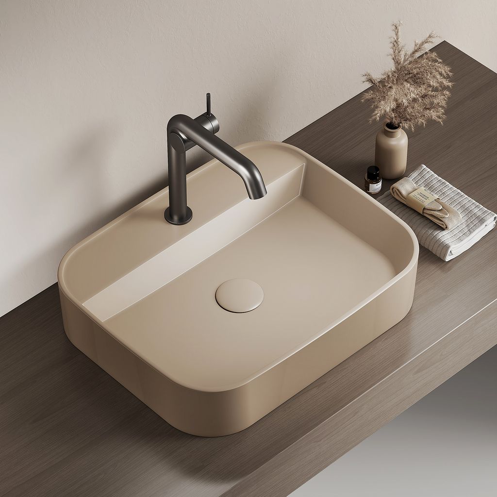 A modern beige sink with a dark gray faucet is shown on a wooden countertop.