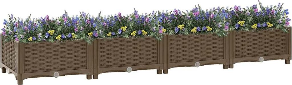 A long, brown, modular planter box filled with purple and yellow flowers.