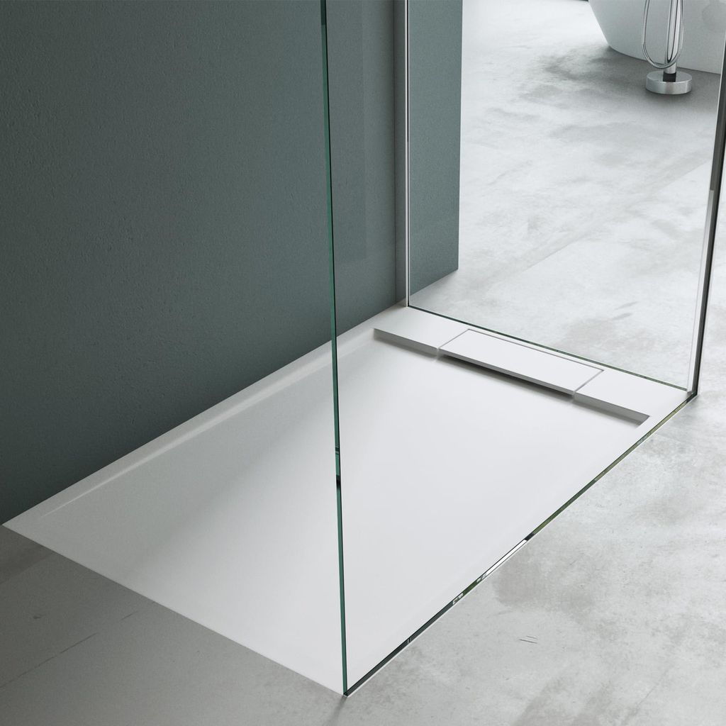 A modern white shower tray with a glass partition in a bathroom.