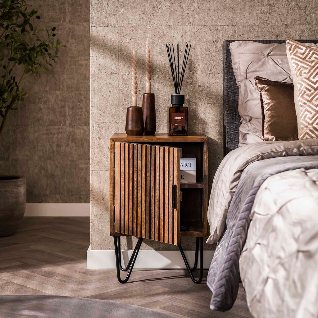 A bedroom scene with a nightstand next to a bed.