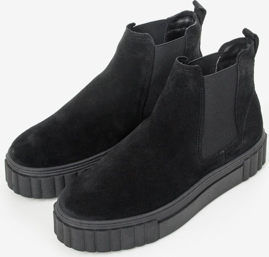 A pair of black Chelsea boots with thick soles are shown against a white background.