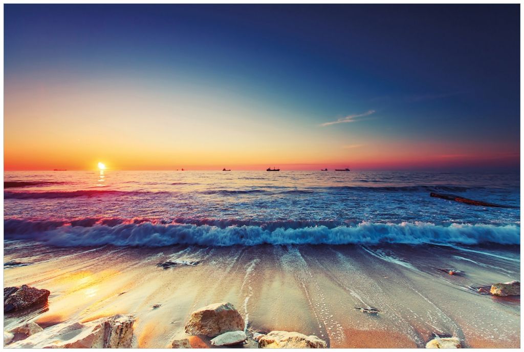 Wallario Premium Glasbild, freischwebende Optik, kräftige Farben, Größe 90 x 60 cm Motiv Sonnenuntergang am Meer mit Wellen am Strand
