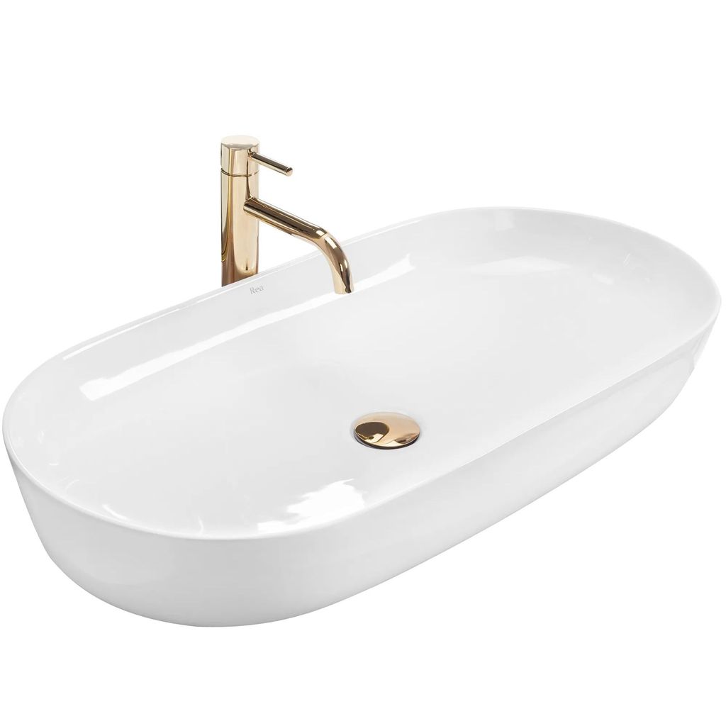A white oval basin with a gold faucet and drain.