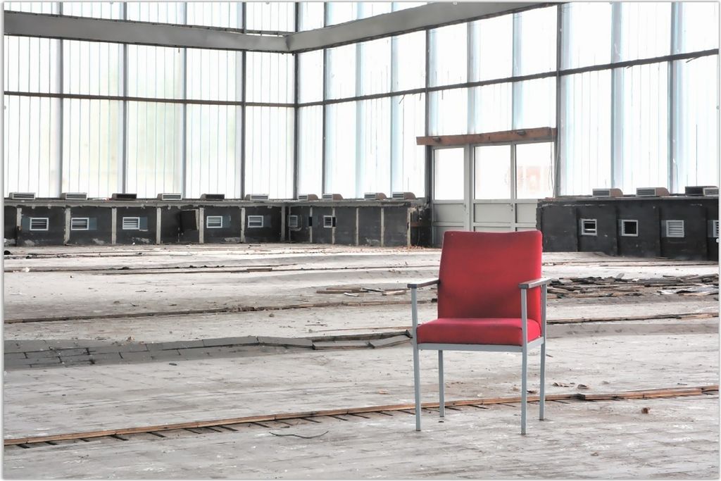 Wallario Wandbild Stille und Leere - ein einsamer roter Stuhl in einer alten Halle, Größe: 61 x 91,5 cm, Poster mit rahmenlosen Bildhalter