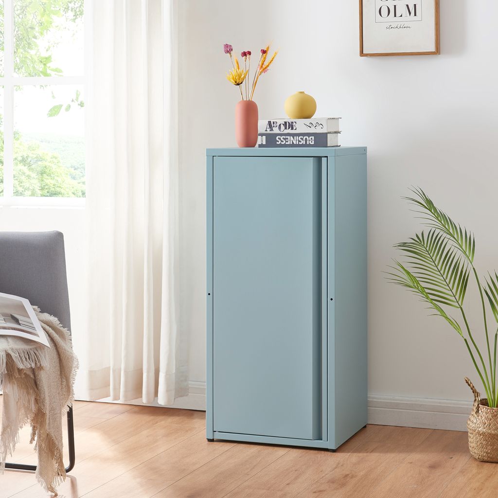 A light blue metal cabinet with sliding doors is shown in a room with a window and curtains.