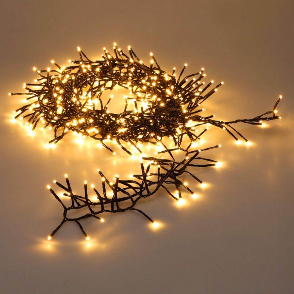 A string of warm white LED lights is coiled on a light gray surface.