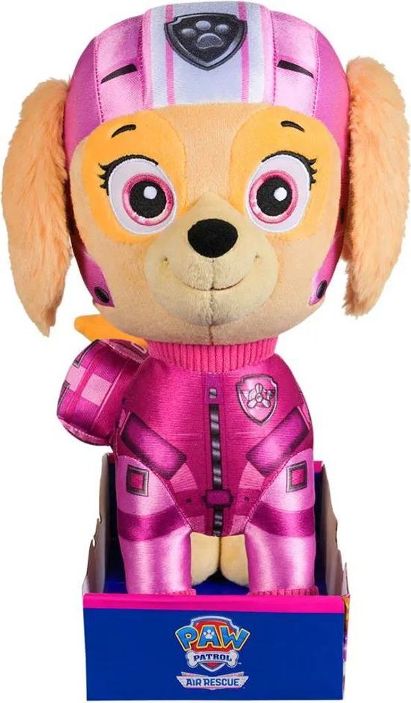 A plush toy of Skye from Paw Patrol in her Air Rescue uniform, standing in a cardboard display box.