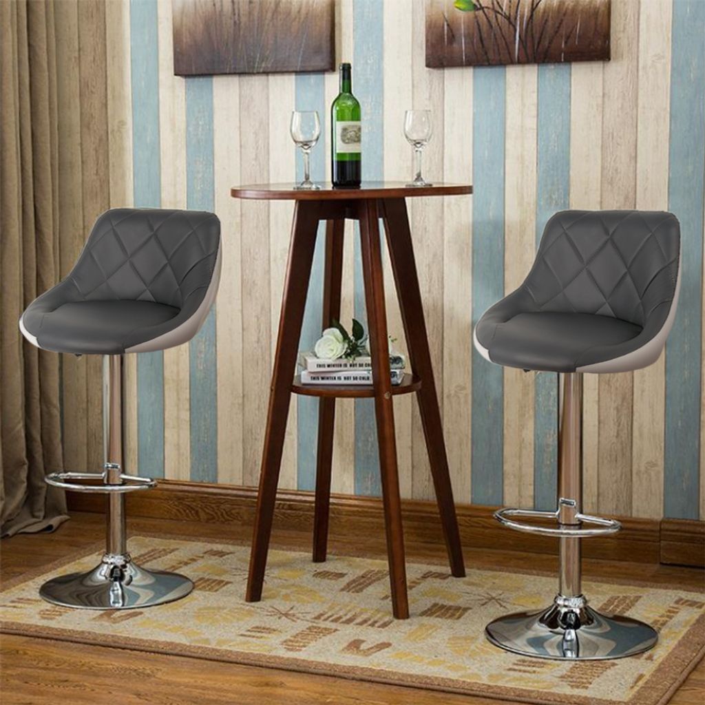 Two bar stools are placed around a small bar table in a room with striped wallpaper.