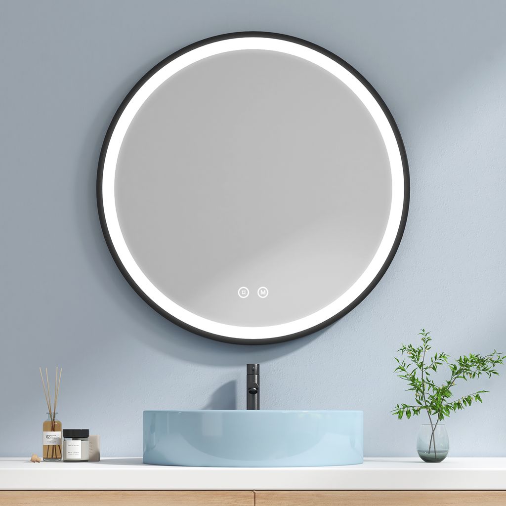 A round LED mirror is mounted above a light blue basin in a bathroom setting.