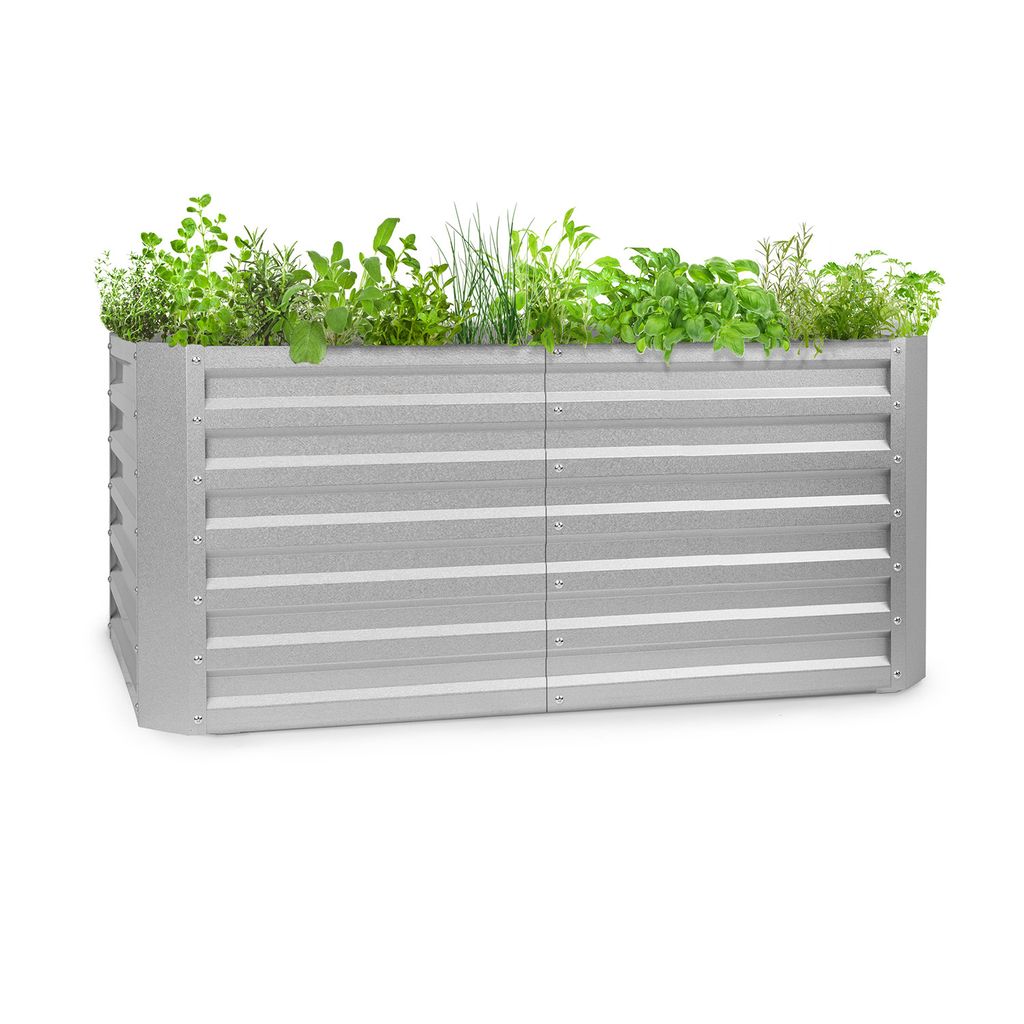 A silver metal raised garden bed filled with various green plants, photographed against a white background.
