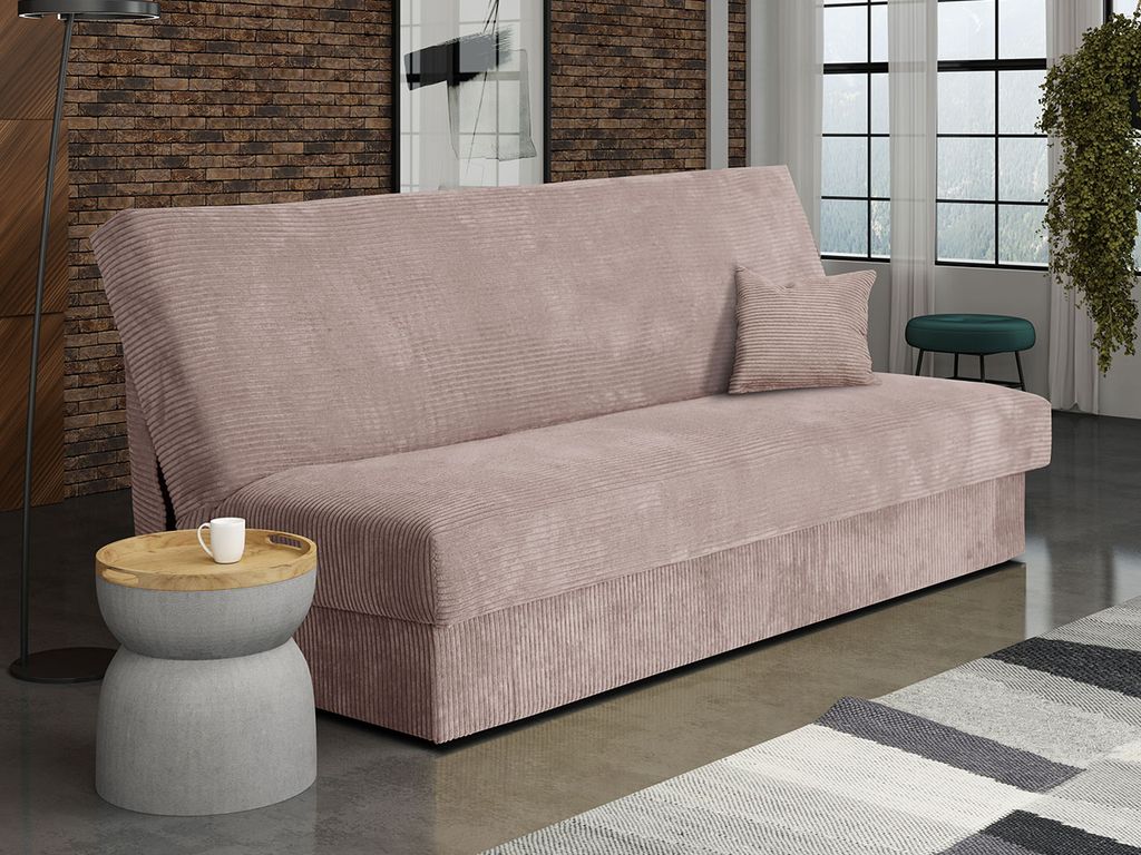 A pink sofa bed is shown in a living room setting with a side table and a rug.