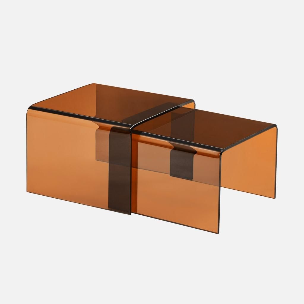 Two nesting coffee tables made of amber-colored glass.