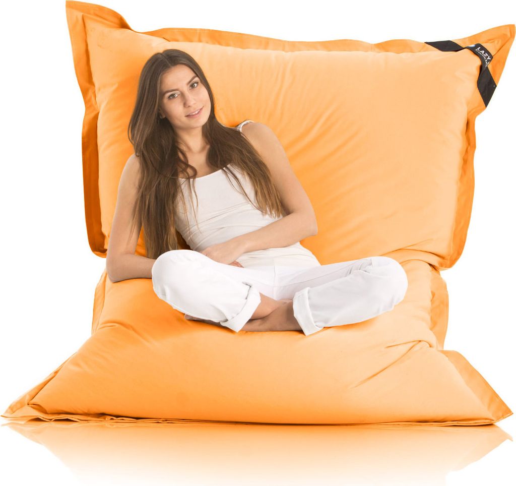 A young woman sitting cross-legged on a large orange beanbag chair.