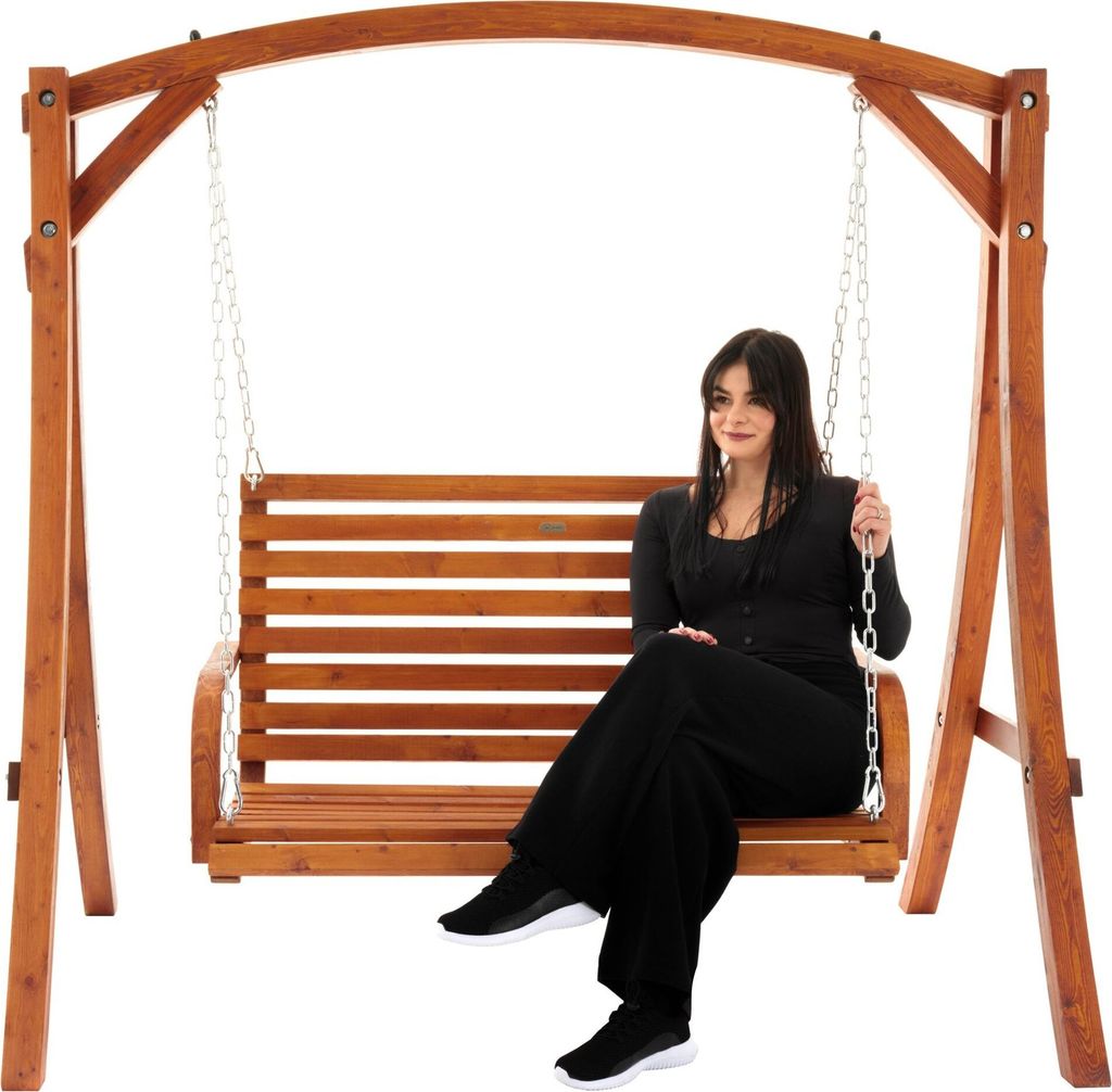 A woman is sitting on a wooden garden swing.