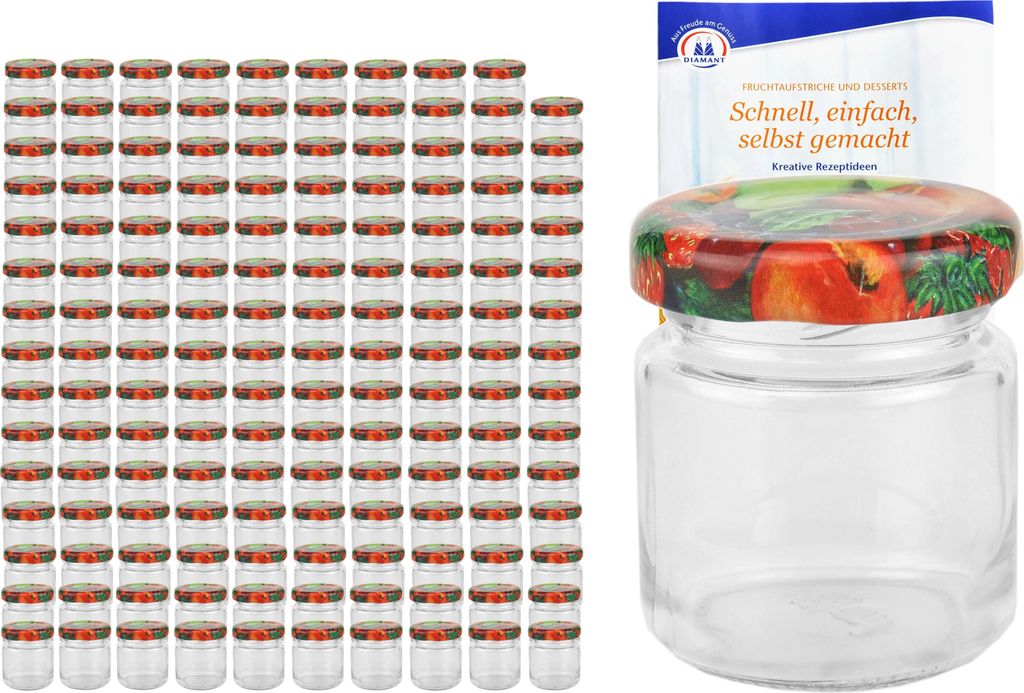 A large stack of small glass jars with fruit-patterned lids, and one jar with a recipe booklet in the background.
