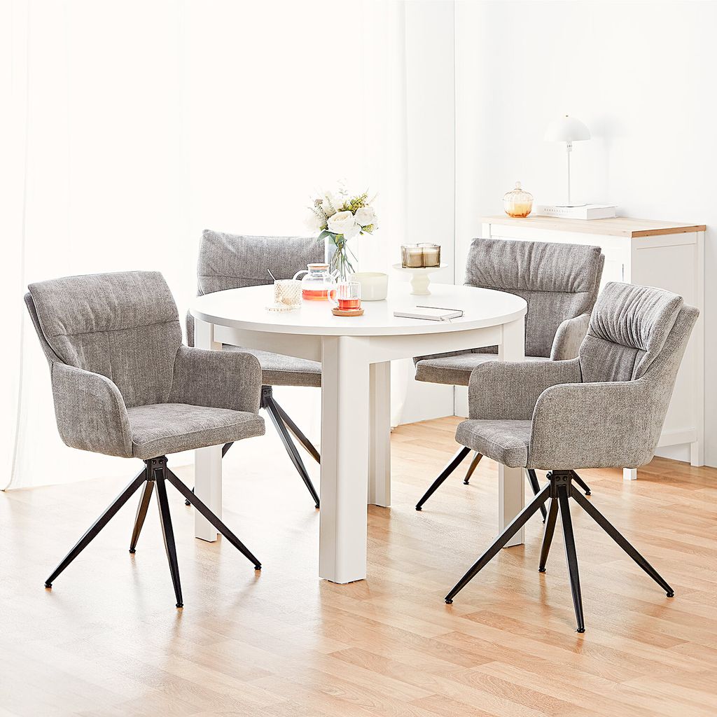A dining set with a round white table and four gray chairs in a well-lit room.