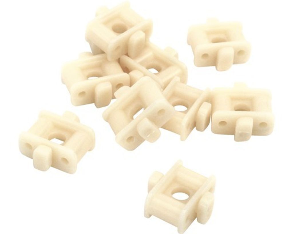 A pile of small, cream-colored plastic plant holders on a white background.