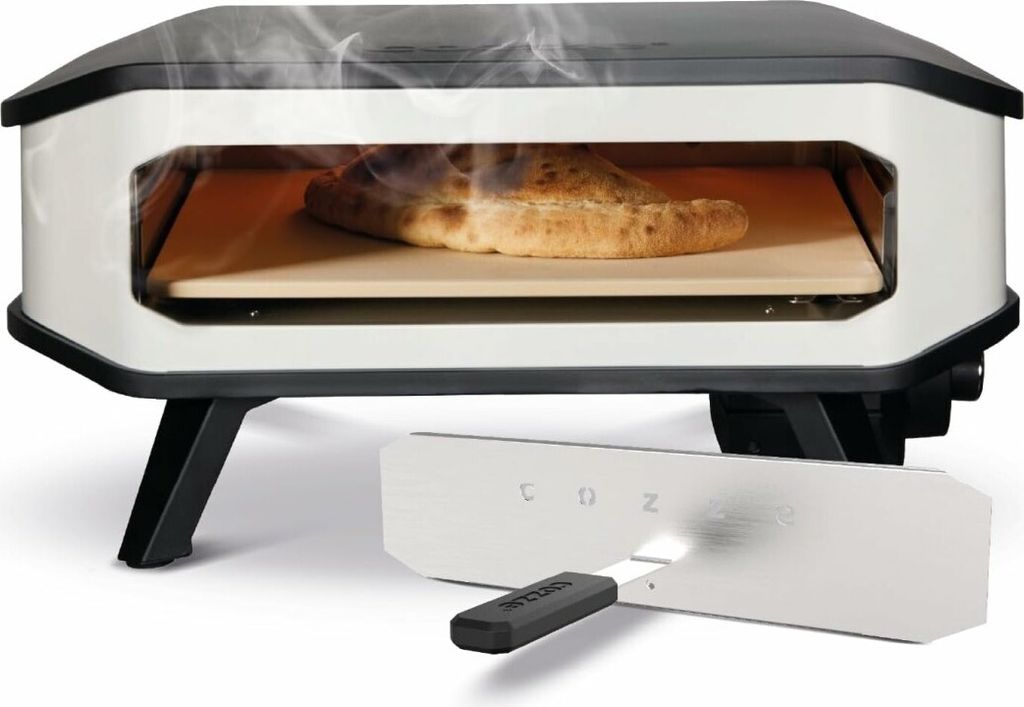 A pizza oven with a pizza inside and a pizza peel in front.