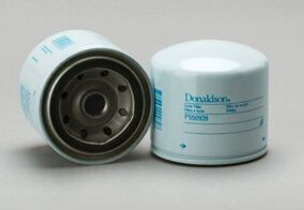 Two white oil filters are shown against a light gray background. One filter is shown from the side, with its internal filtering material visible. The other filter is shown from the top, with branding and product information printed on its side.
