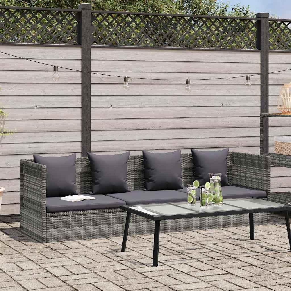An outdoor sofa set with a coffee table on a paved patio, with a wooden fence and string lights in the background.