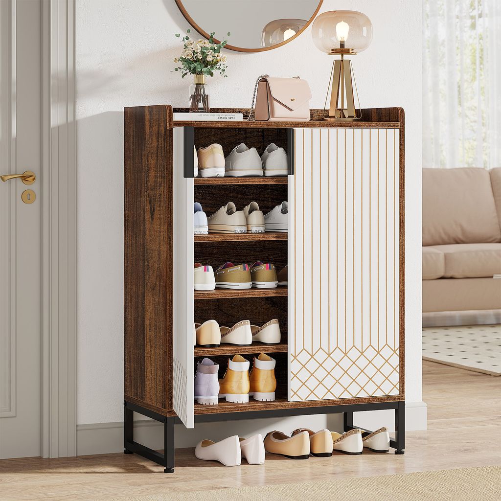 A shoe cabinet with shoes on shelves and on the floor in a hallway next to a door.