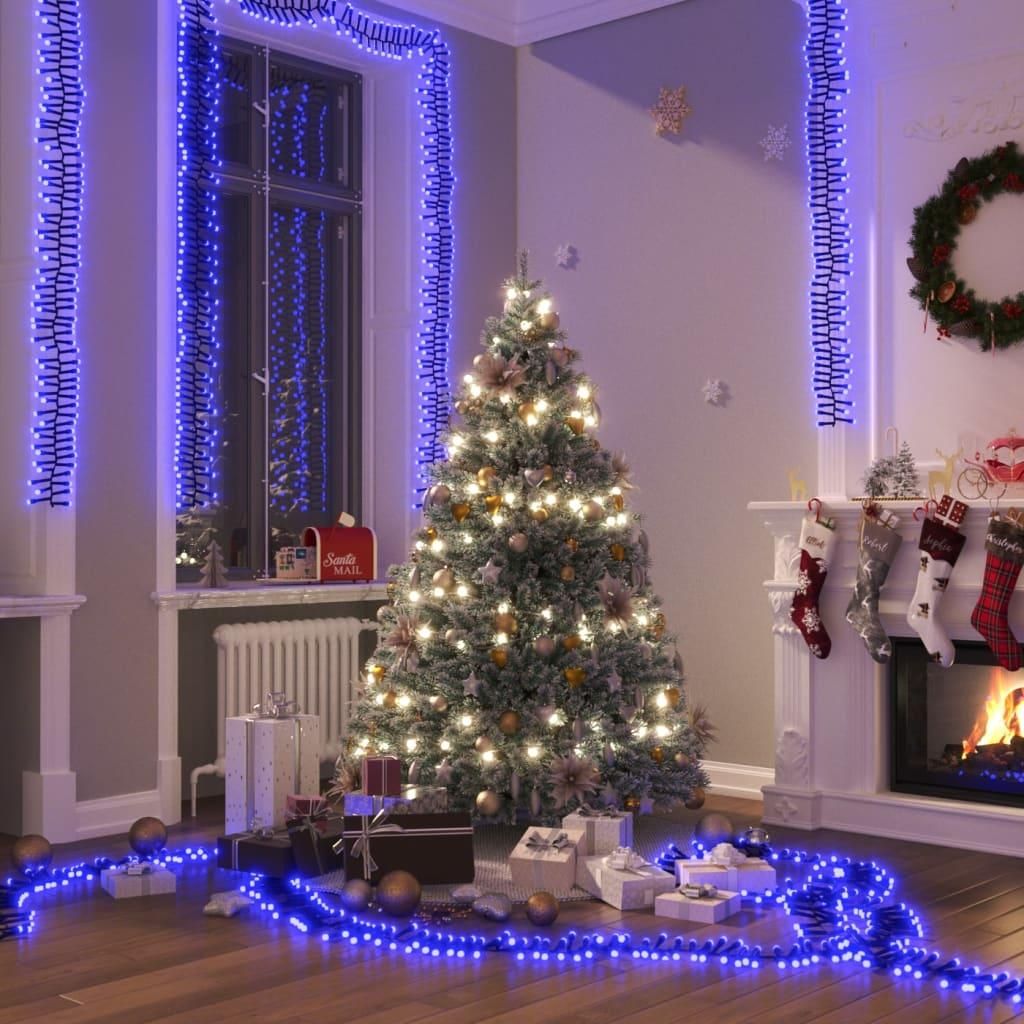 A festive Christmas scene with a decorated tree, fireplace, stockings, and gifts, illuminated by blue LED lights.