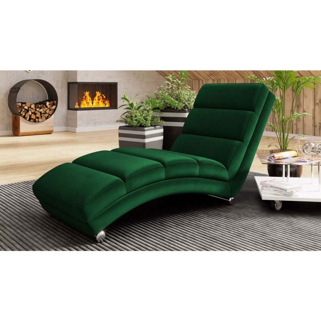 A green chaise lounge is placed in a modern living room with a fireplace and plants.