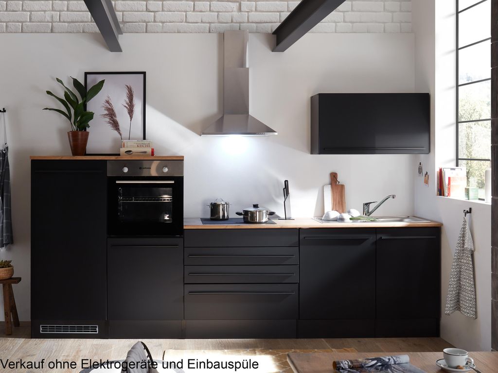 A modern black kitchen with wooden countertops, featuring an oven, sink, and cabinetry.