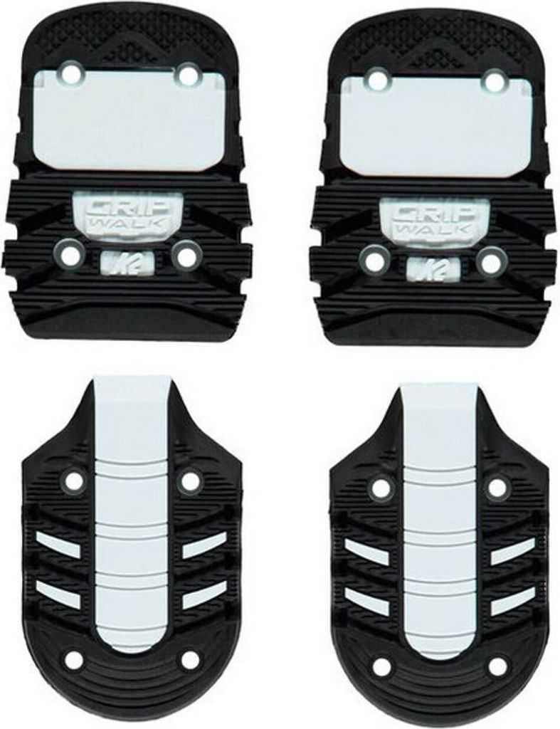 Four ski boot soles are arranged in a two-by-two grid against a white background.