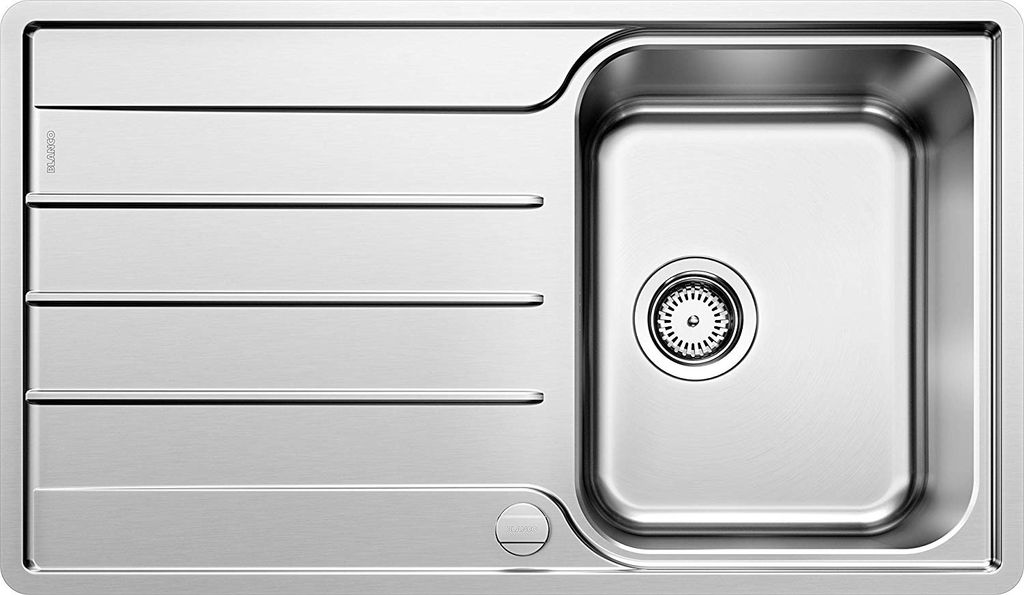 A top-down view of a stainless steel kitchen sink with a drainboard.
