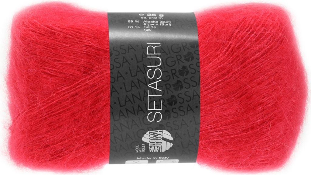A ball of red yarn with a black label wrapped around it.