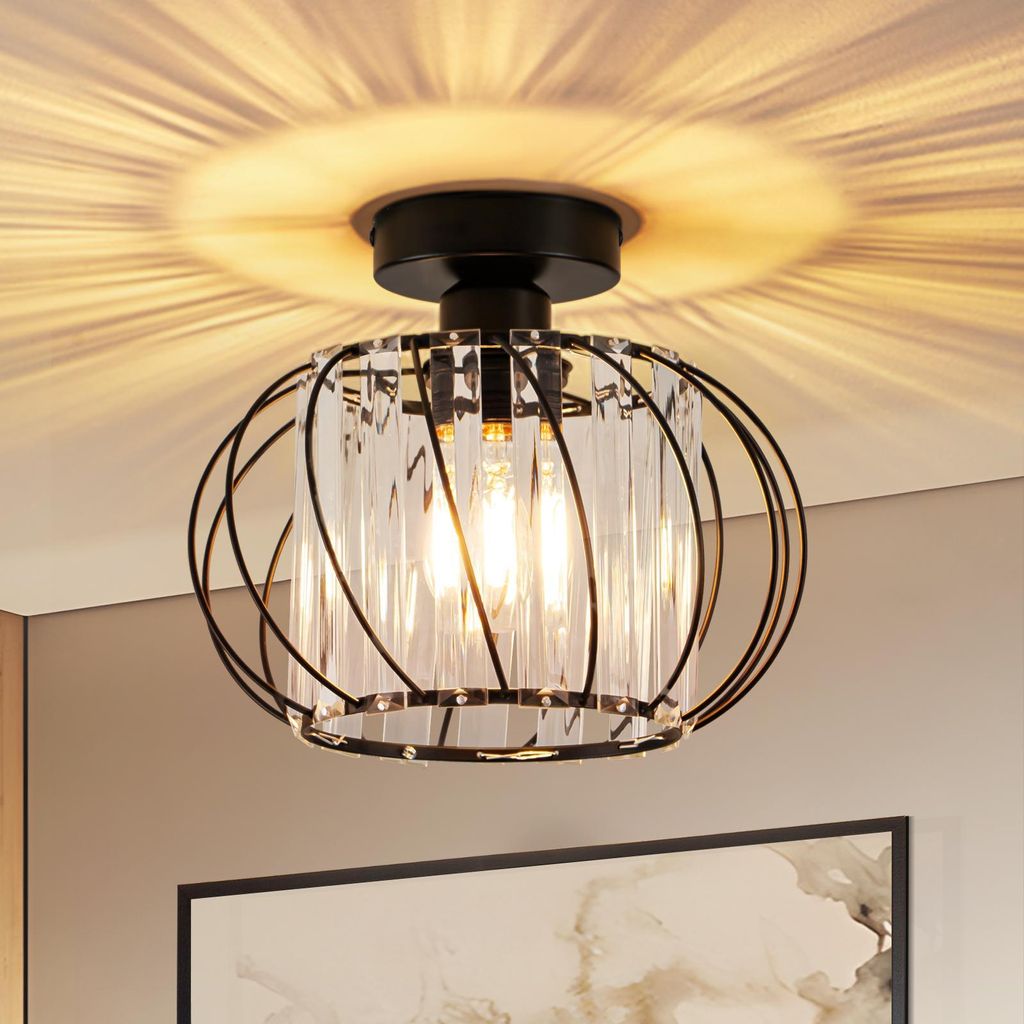 A close-up shot of a black metal and crystal ceiling light fixture, casting a patterned light on the ceiling.