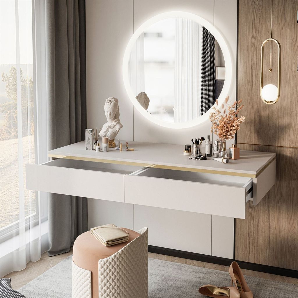 A modern vanity console with a round illuminated mirror, makeup, and decorative items, set in a well-lit room with a window and curtains.