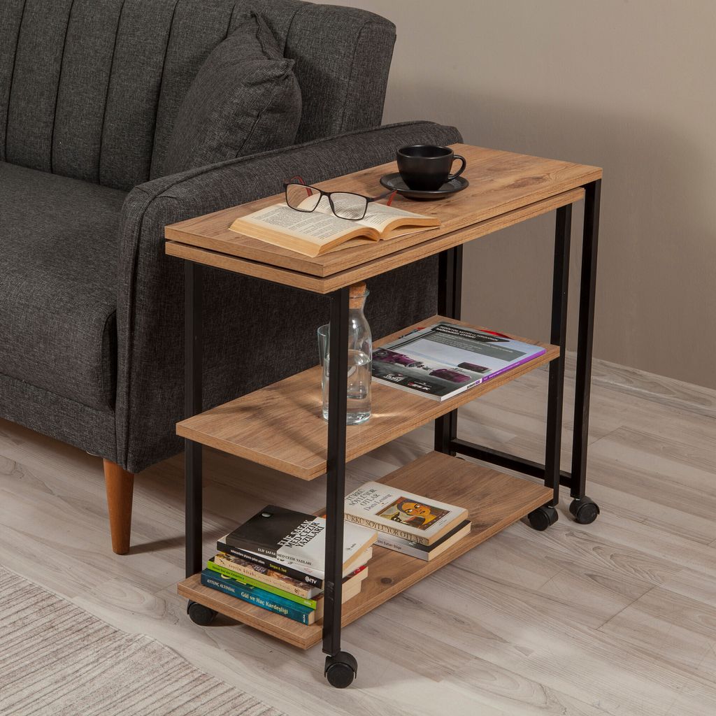 A side table next to a sofa, with books, glasses, and a cup of coffee on it.