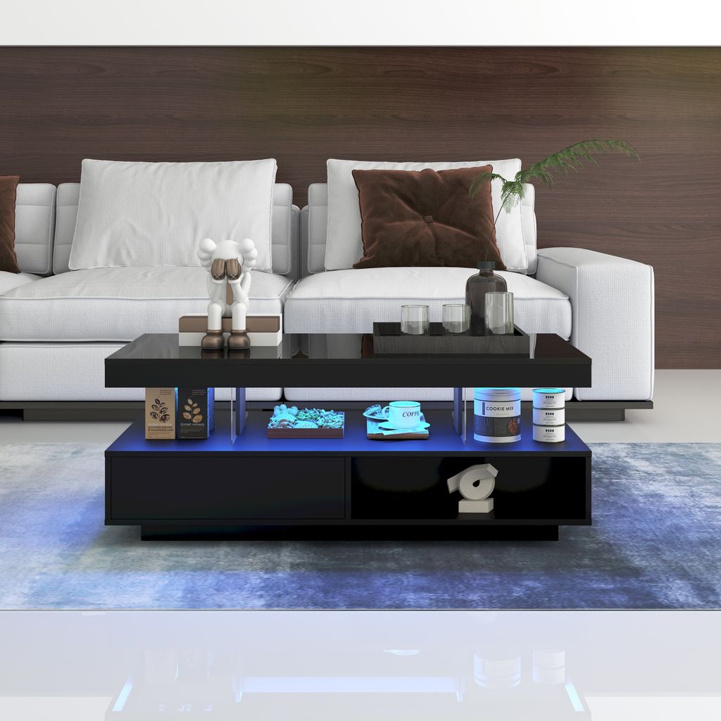 A modern living room with a white sofa and a black coffee table with LED lighting.