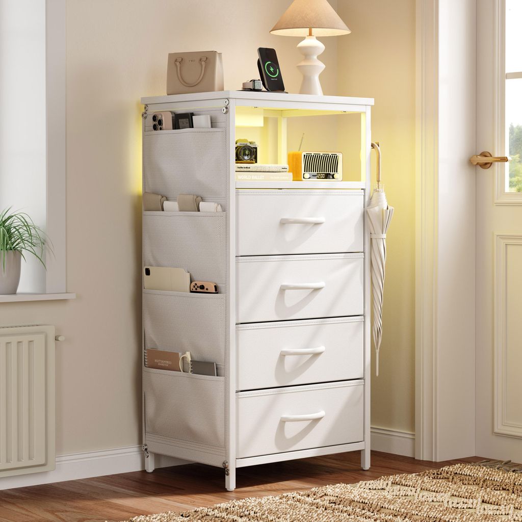 A white nightstand with LED lighting, charging station, and side pockets, placed in a room setting.