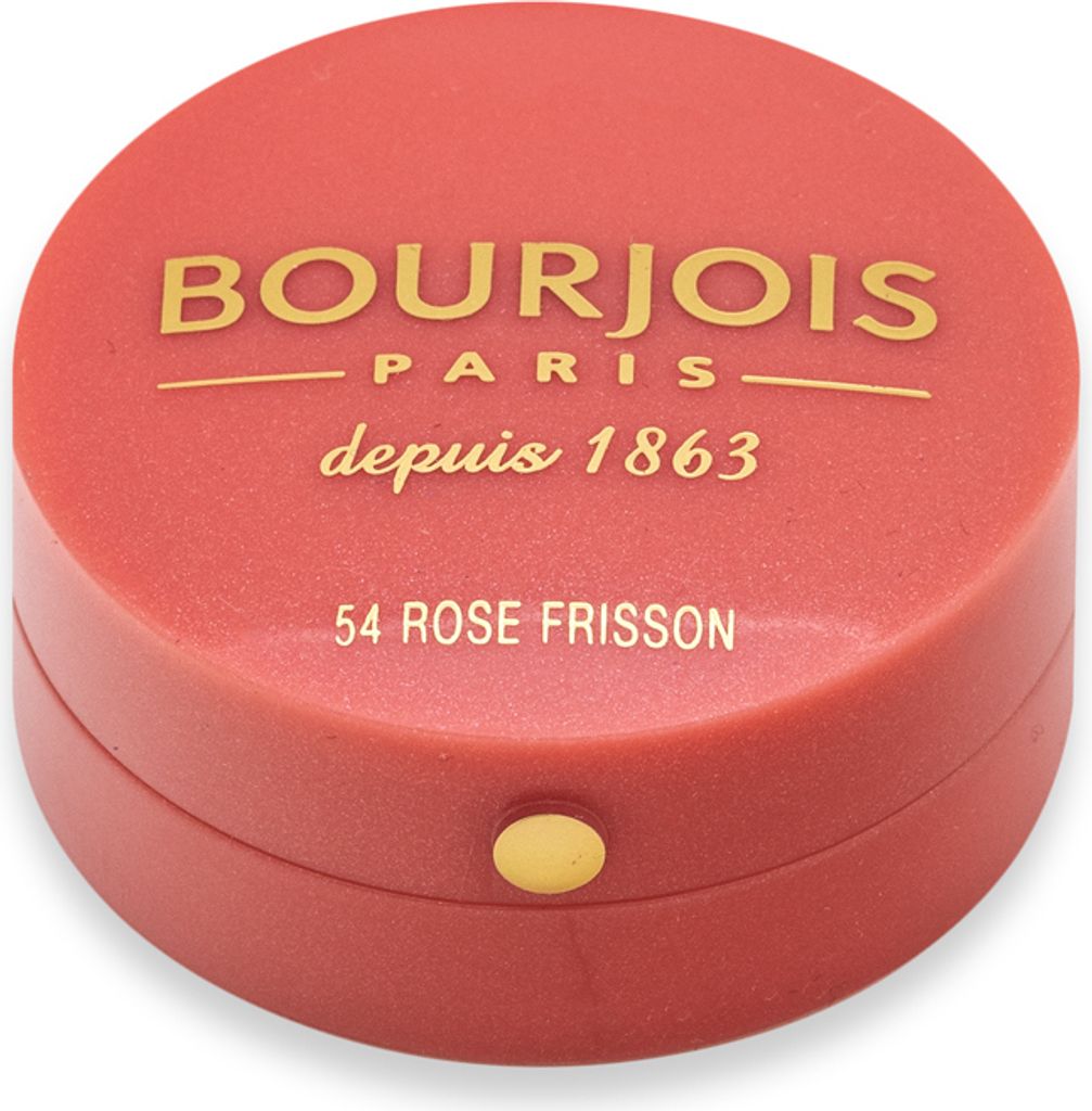 A close-up, top-down view of a small, round, coral-colored makeup compact with gold lettering and a gold button.