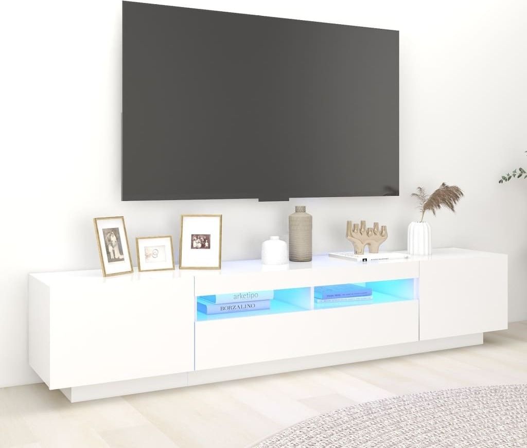A modern white TV stand with LED lighting displays decorative items and books.