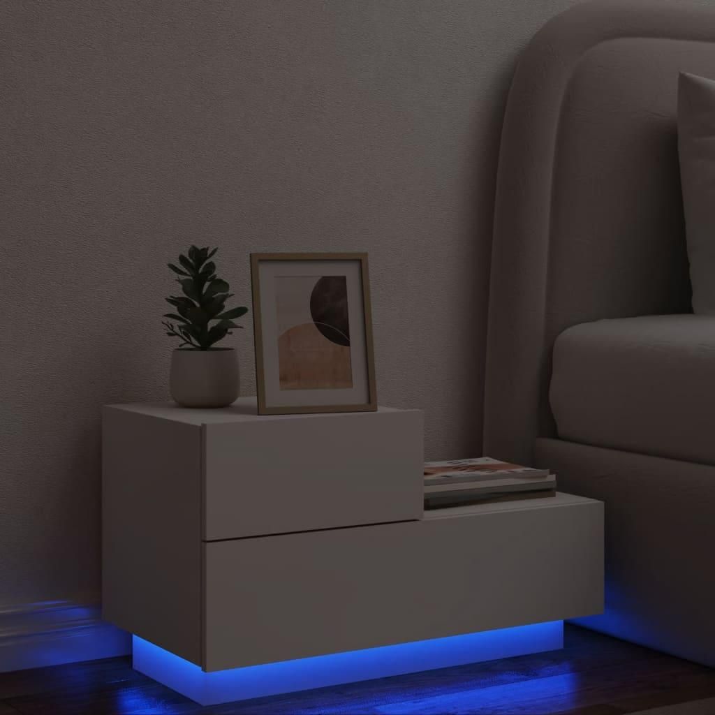 A white nightstand with LED lighting is shown next to a bed.