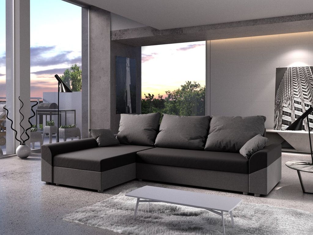 A modern living room with a large sectional sofa, large windows overlooking a sunset, and minimalist decor.