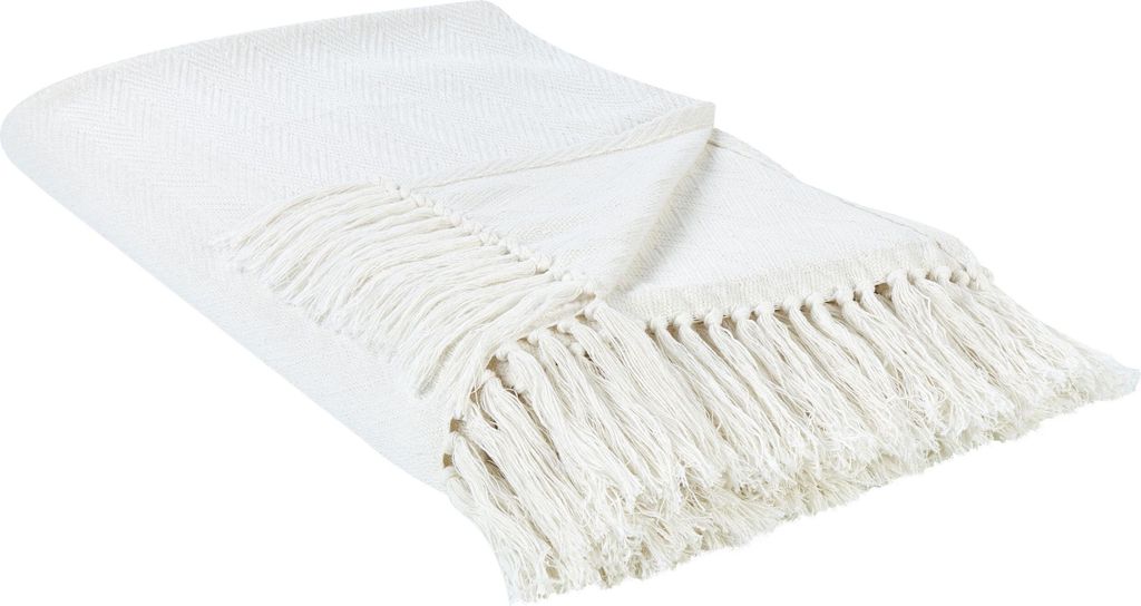 A white blanket with fringe is laid out on a white background.