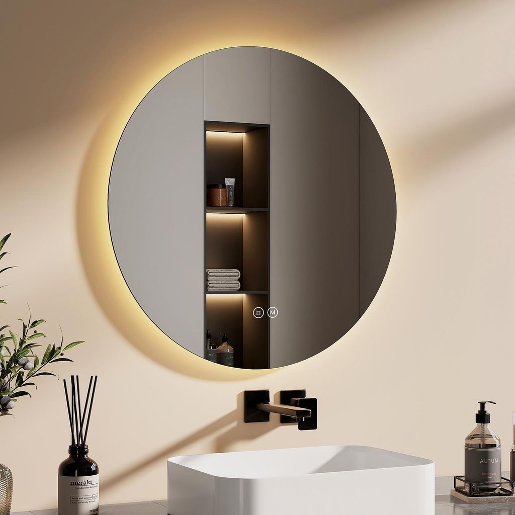 A modern bathroom setting with a round LED mirror above a sink and faucet.