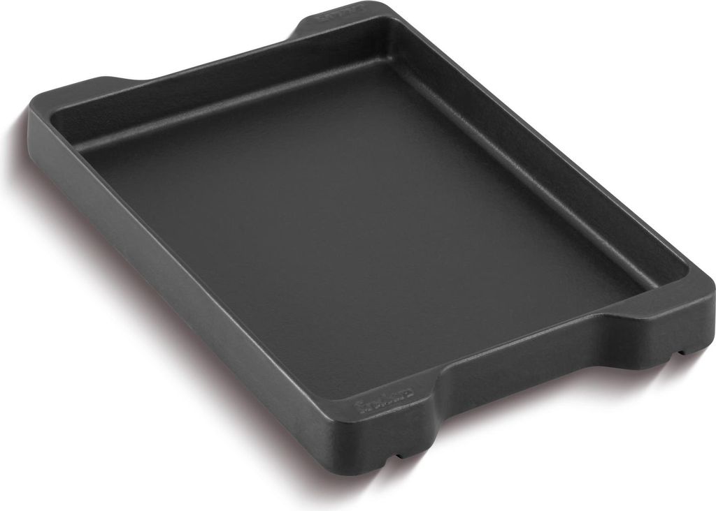 A black rectangular griddle plate with raised edges and two handles on the top side, shown at an angle against a white background.