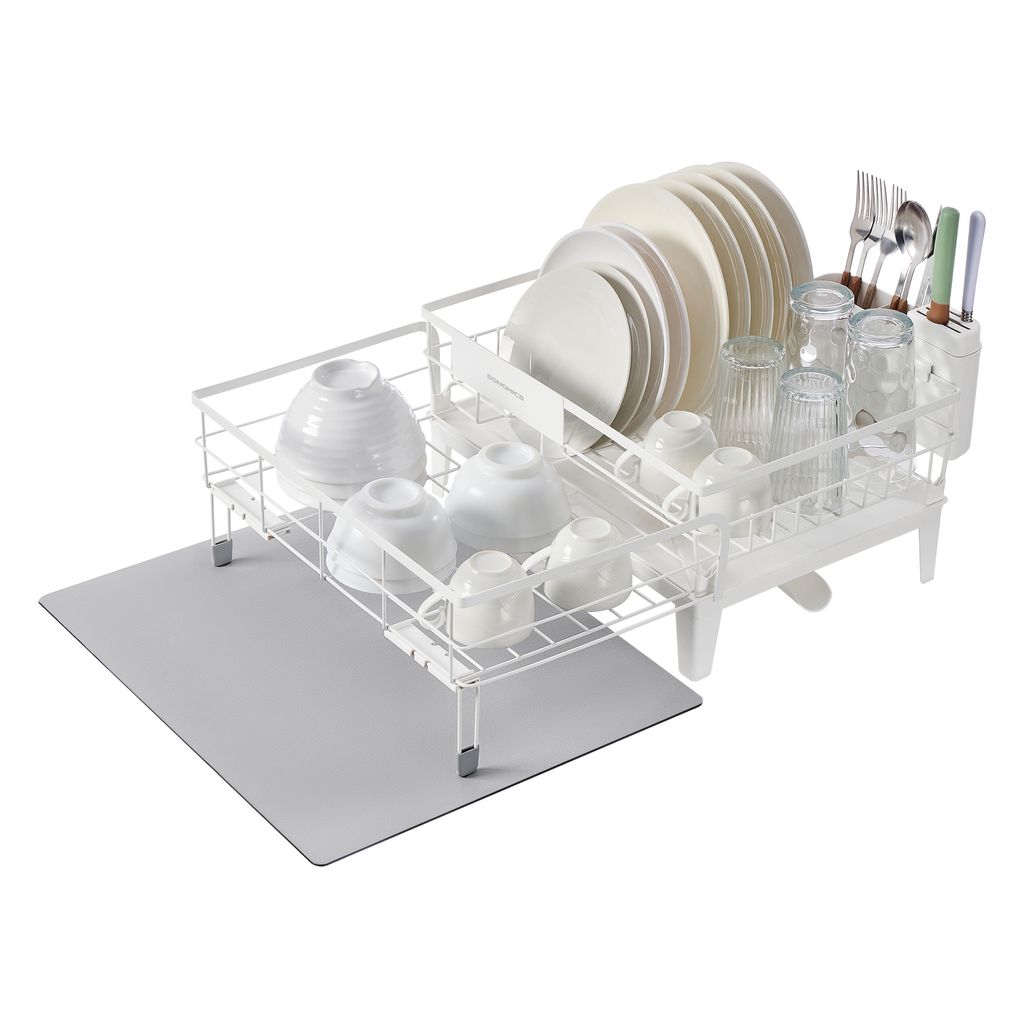 A white wire dish rack filled with various dishes and glasses, placed on a gray mat. The dish rack is positioned at an angle on a white background.