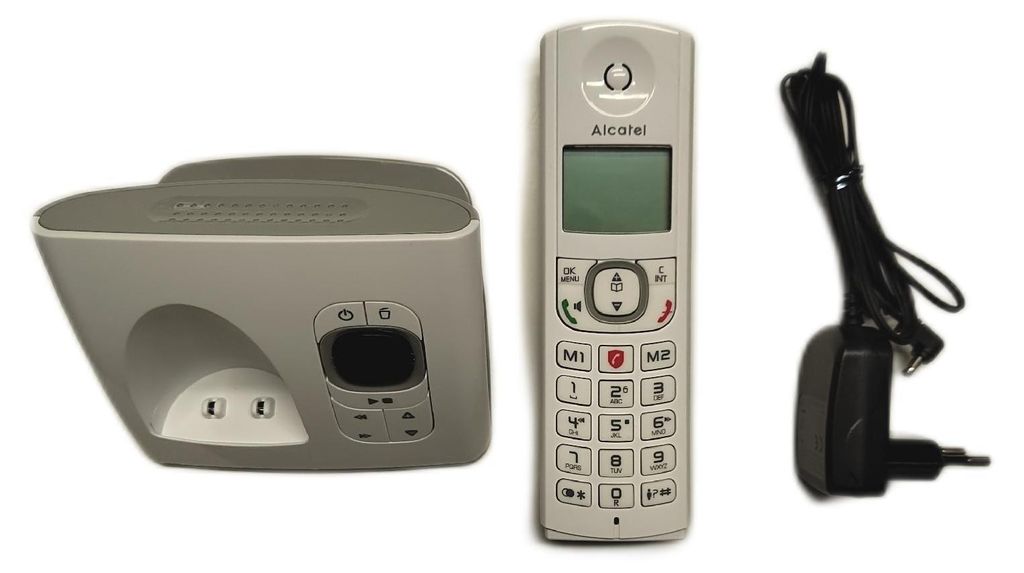 A cordless phone, its base station, and a power adapter are laid out against a white background.