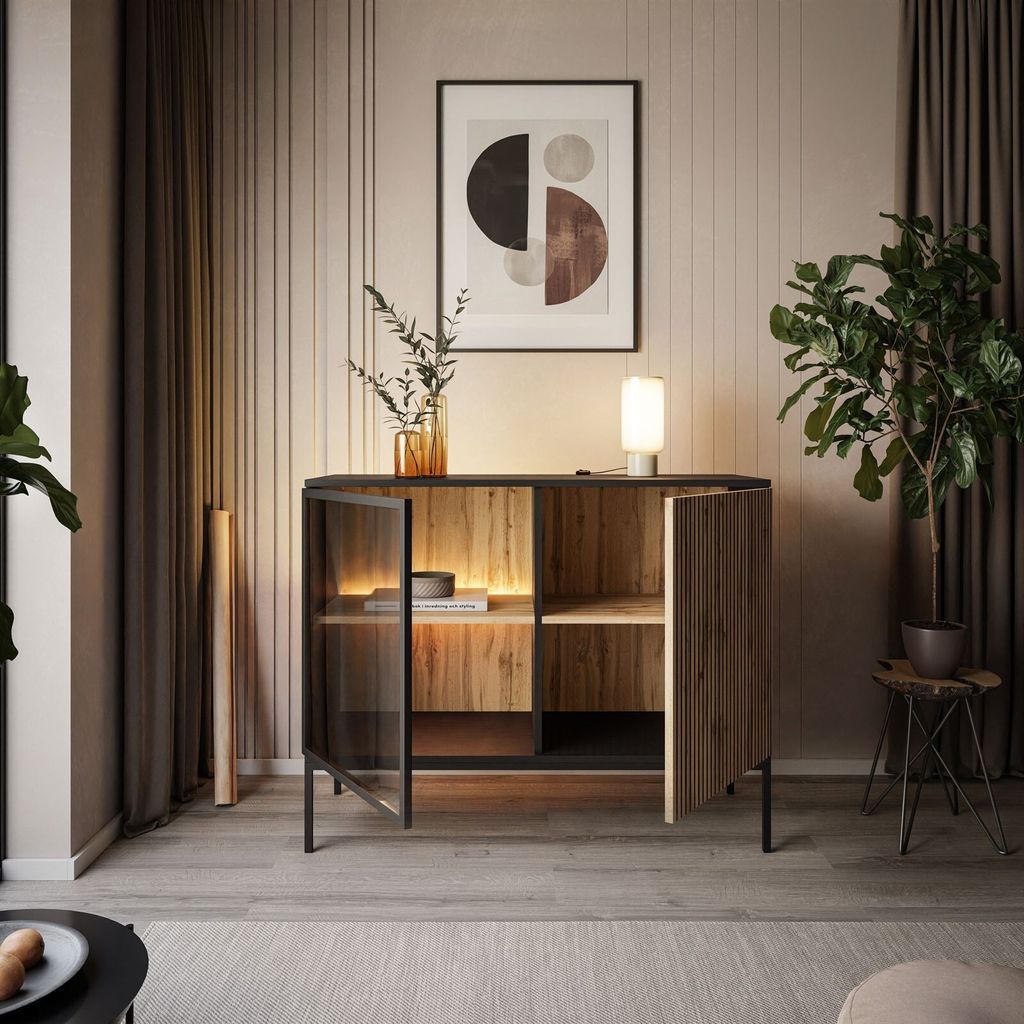 A modern living room with a cabinet, artwork, and a plant.